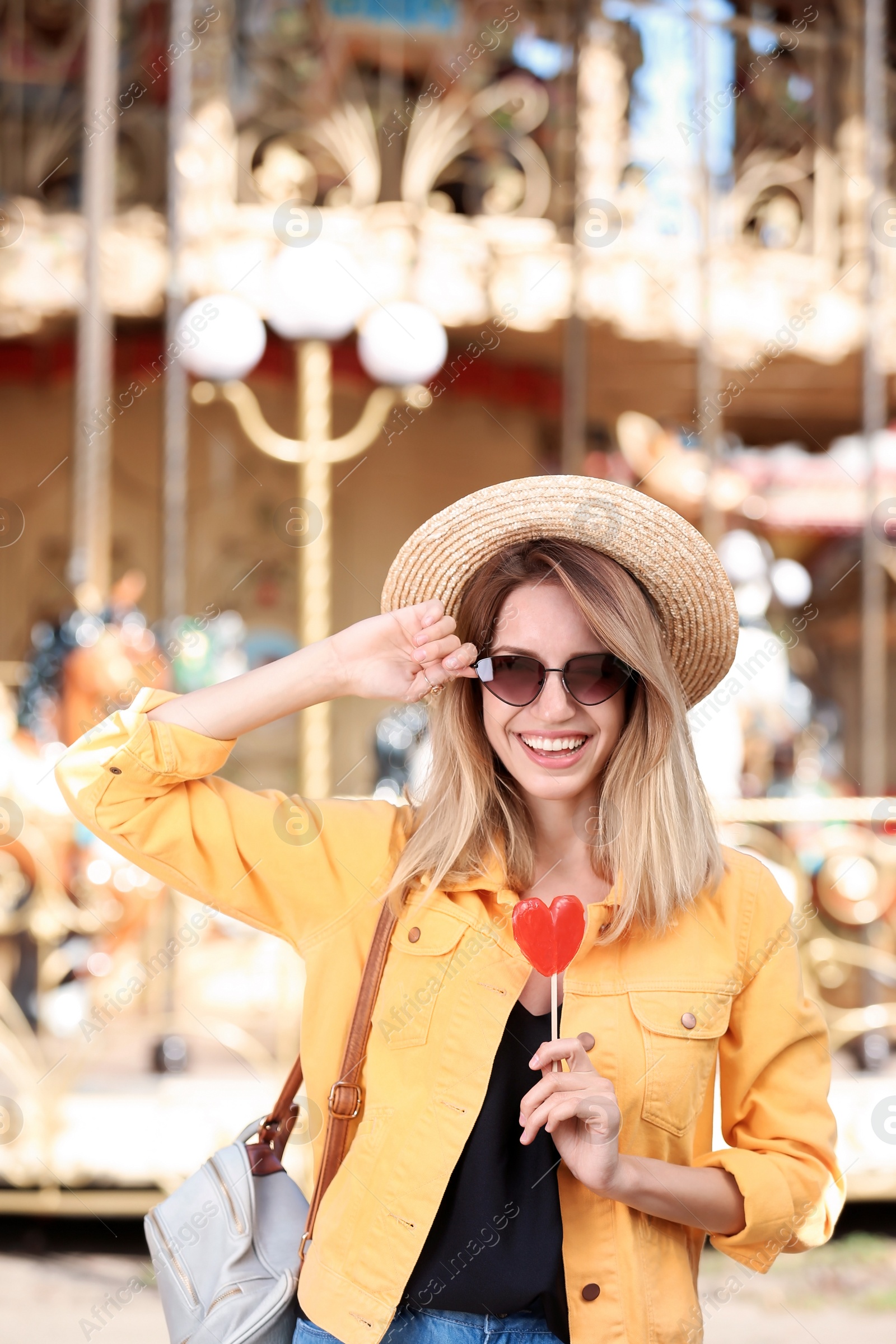 Photo of Beautiful woman with candy having fun at amusement park