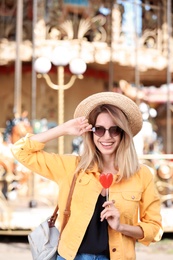 Beautiful woman with candy having fun at amusement park