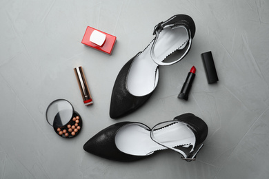 Photo of Flat lay composition with stylish shoes and cosmetics on grey table