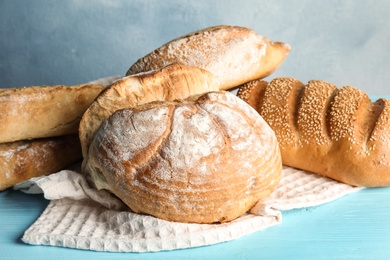 Photo of Pile of fresh bread on table against color background, closeup