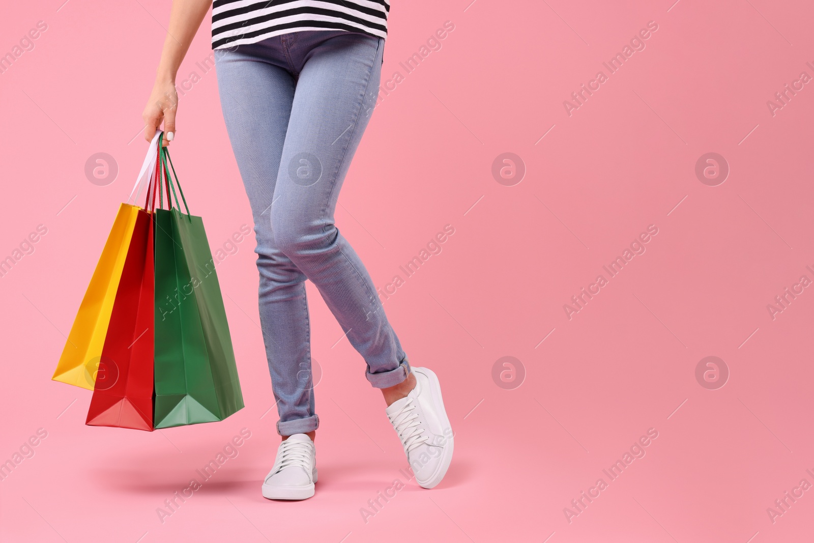 Photo of Woman with shopping bags on pink background, closeup. Space for text