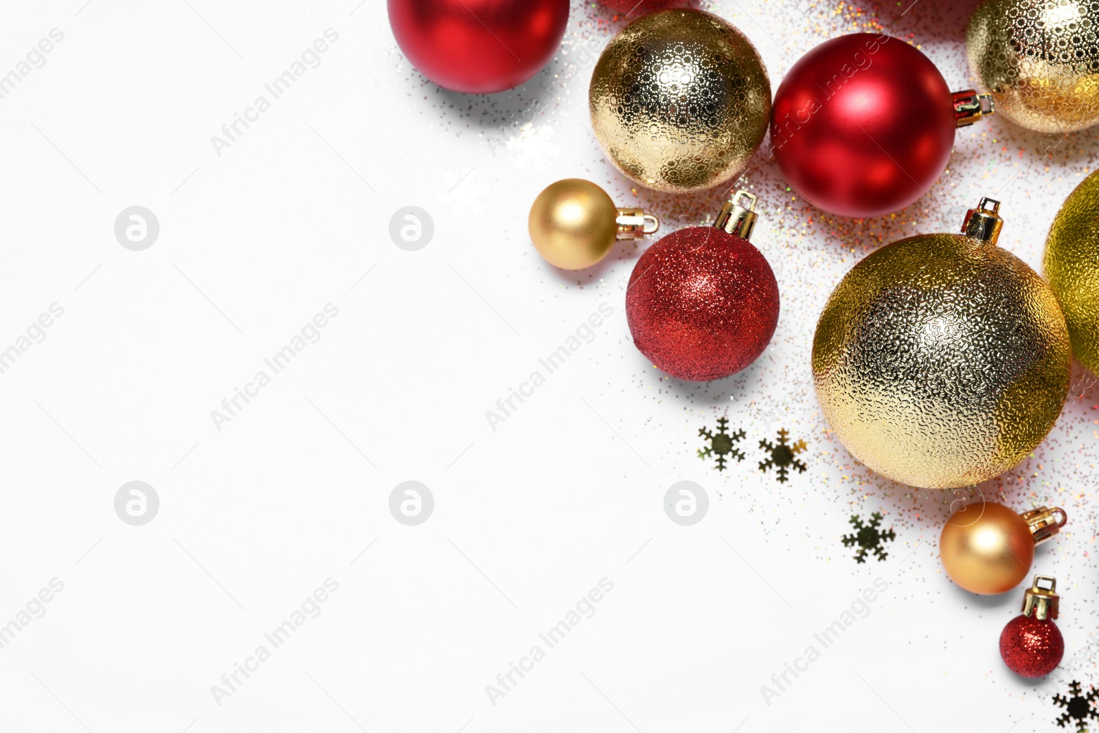 Photo of Christmas balls, confetti and glitter on white background, flat lay. Space for text