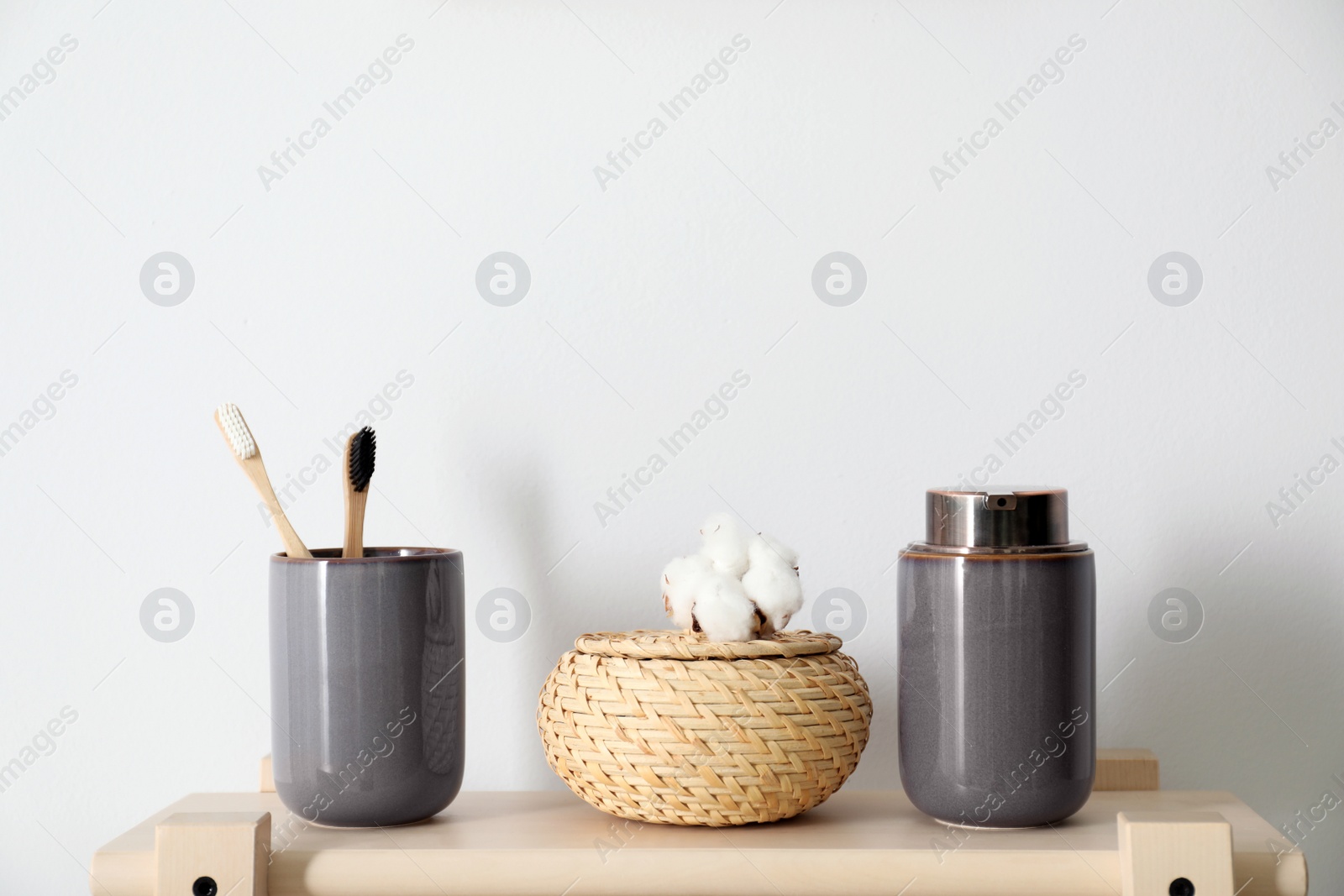 Photo of Wooden shelf with toiletries near white wall, space for text. Bathroom interior element