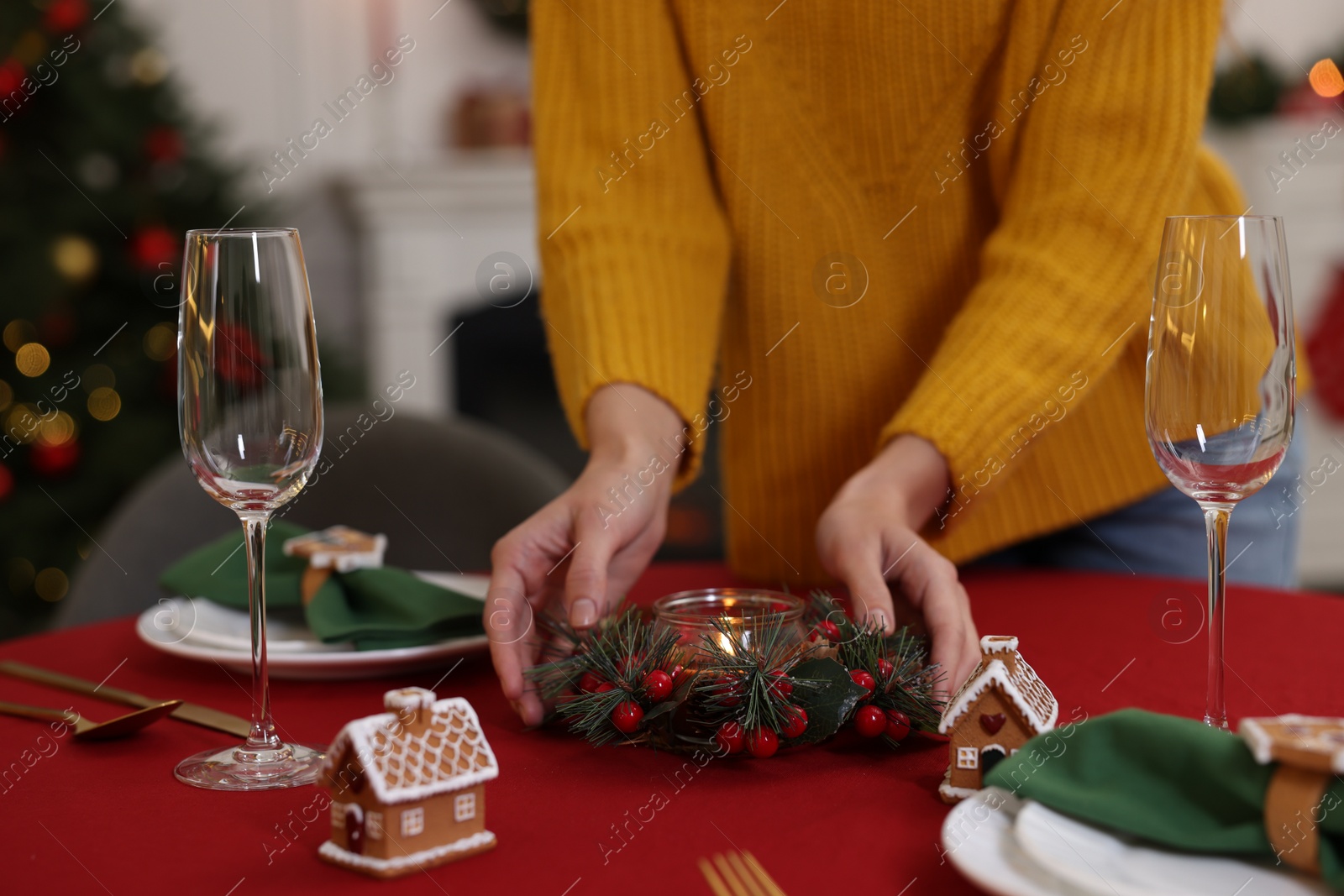 Photo of Woman setting table for Christmas celebration at home, closeup
