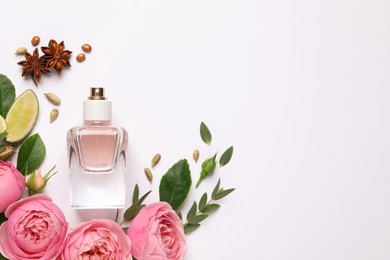 Photo of Flat lay composition with bottleperfume, lime and beautiful flowers on white background. Space for text