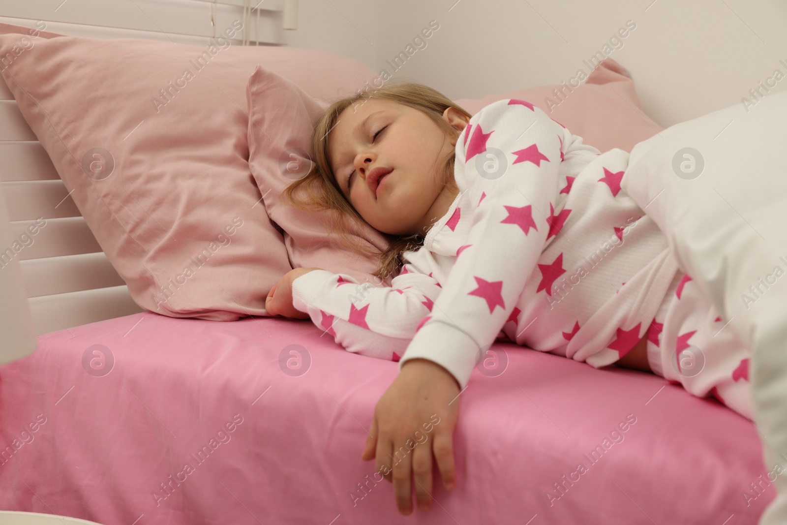 Photo of Little girl snoring while sleeping in bed at home