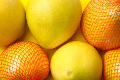 Photo of Tasty fresh pomelo fruits on yellow background, top view