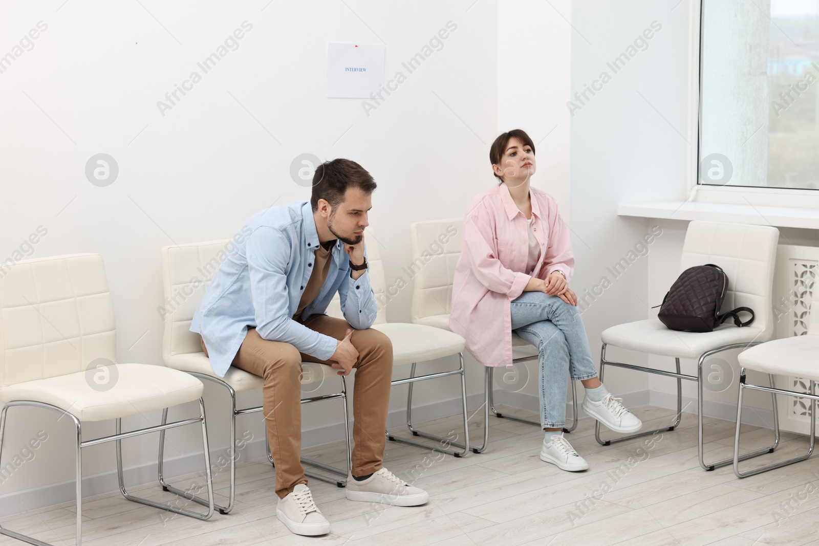 Photo of Man and woman waiting for job interview indoors