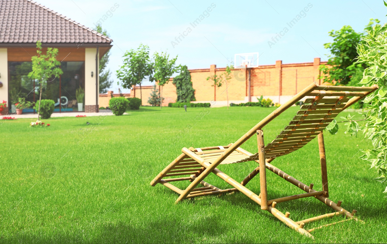 Photo of Wooden deck chair in beautiful garden on sunny day. Space for text