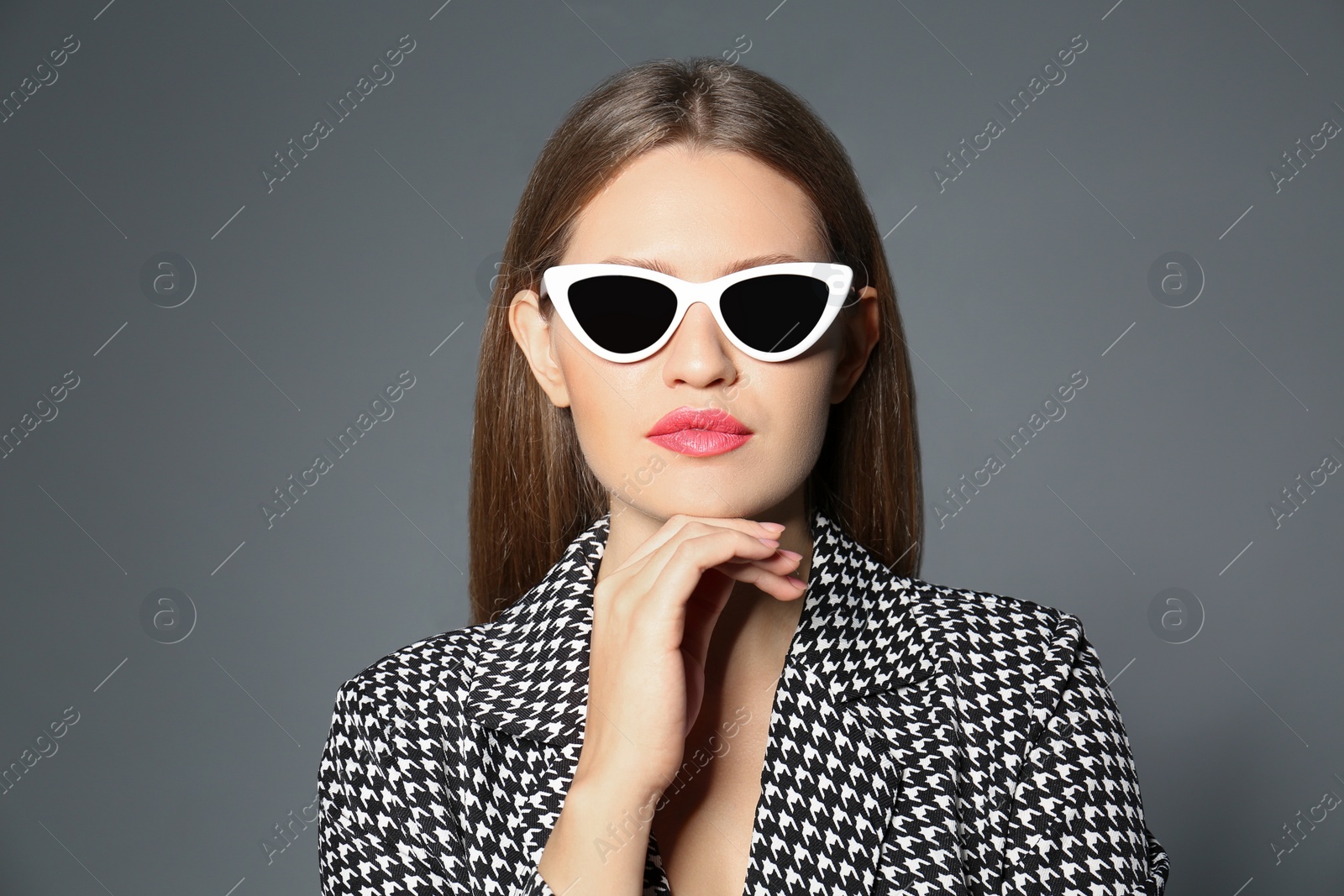 Photo of Young woman wearing stylish sunglasses on grey background