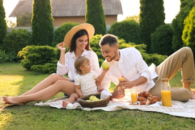 Happy family having picnic in garden on sunny day
