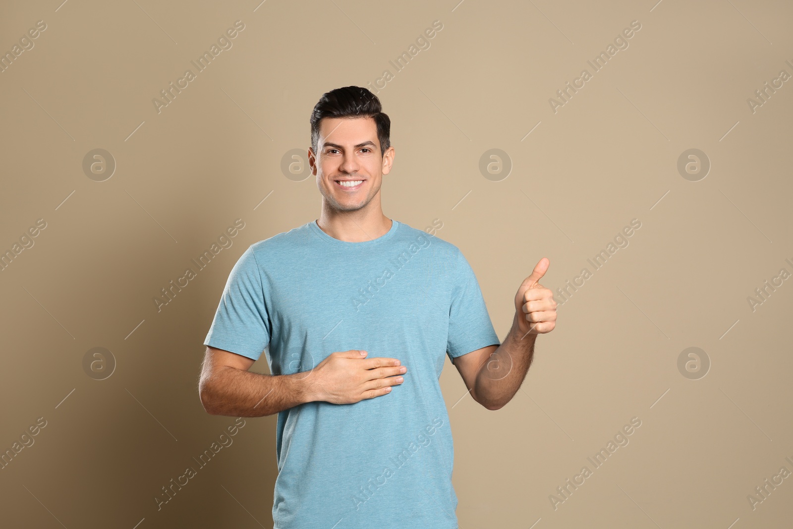 Photo of Happy healthy man touching his belly on beige background