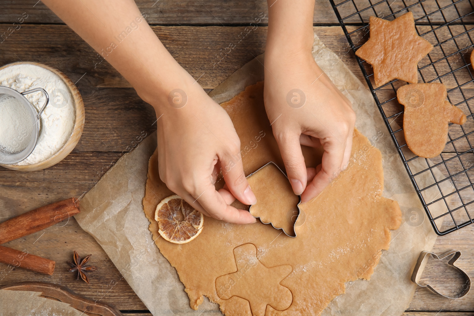 Photo of Woman making Christmas cookies at wooden table, top view