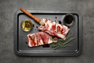 Photo of Fresh raw ribs on grey table, top view