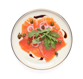 Delicious salmon carpaccio with arugula, capers and onion on white background, top view