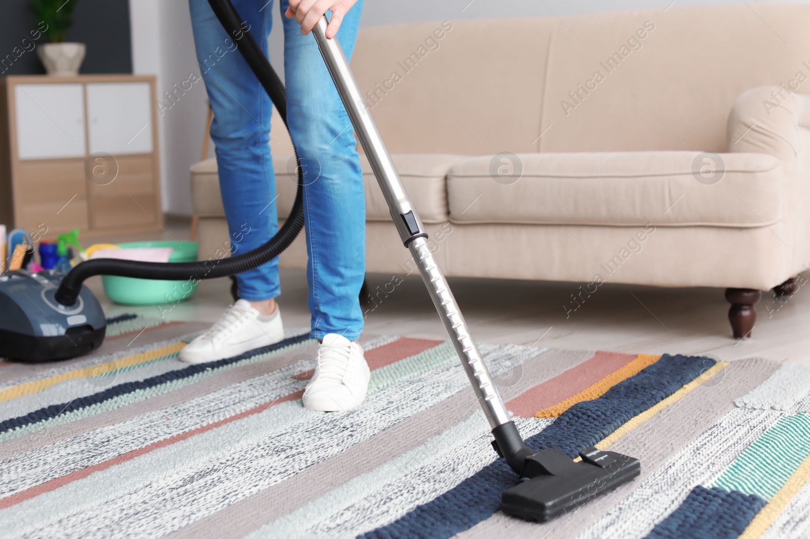 Photo of Man hoovering carpet with vacuum cleaner at home