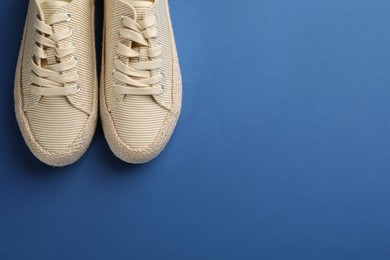 Pair of stylish comfortable shoes on blue background, flat lay. Space for text