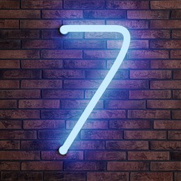 Image of Glowing neon number 7 sign on brick wall