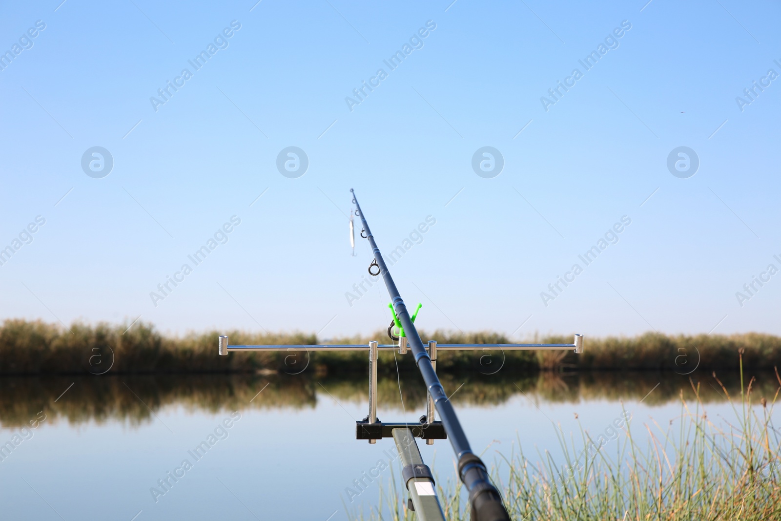 Photo of Fishing rod at riverside on sunny day