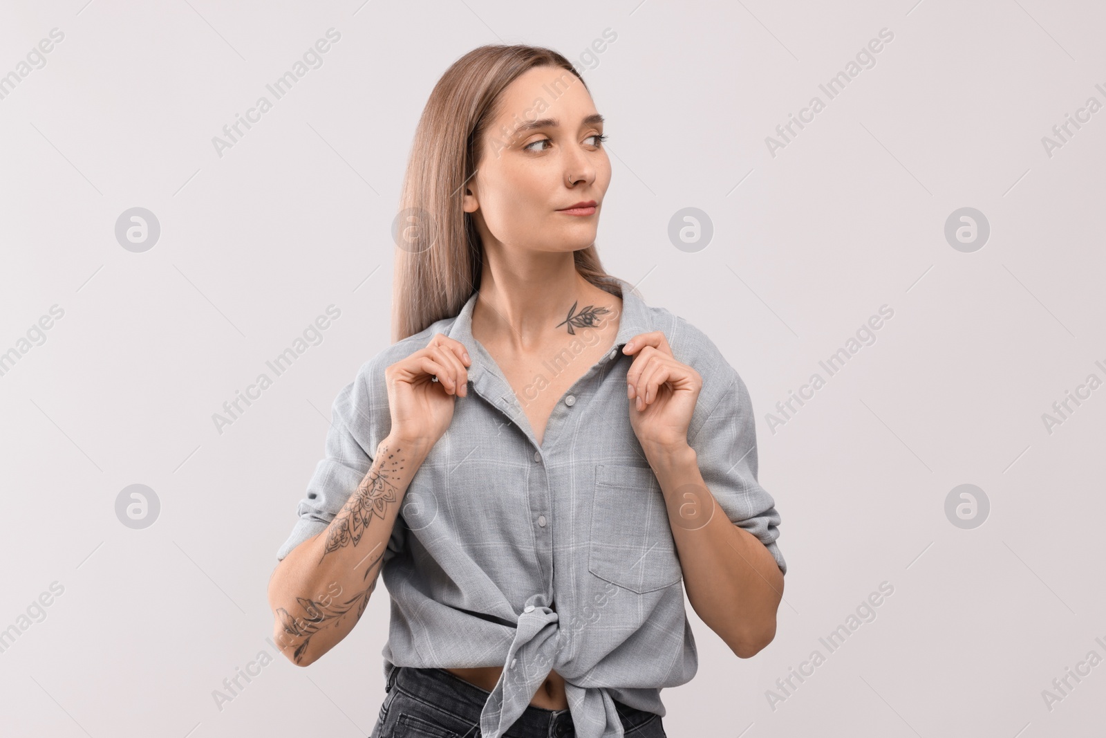 Photo of Portrait of beautiful tattooed woman on light background