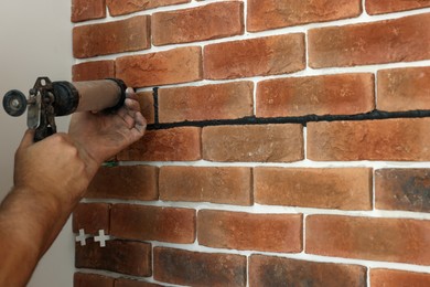 Photo of Professional builder using tiling fugue for grouting, closeup