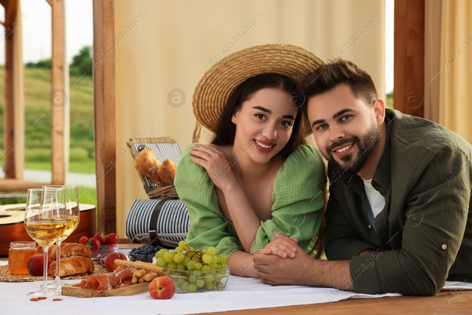 Photo of Romantic date. Beautiful couple spending time together during picnic in wooden gazebo