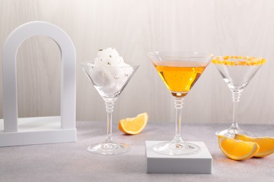Photo of Cotton candy and cocktails in glasses on gray table