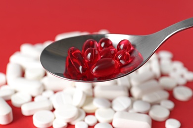 Photo of Spoon with weight loss pills over table, closeup
