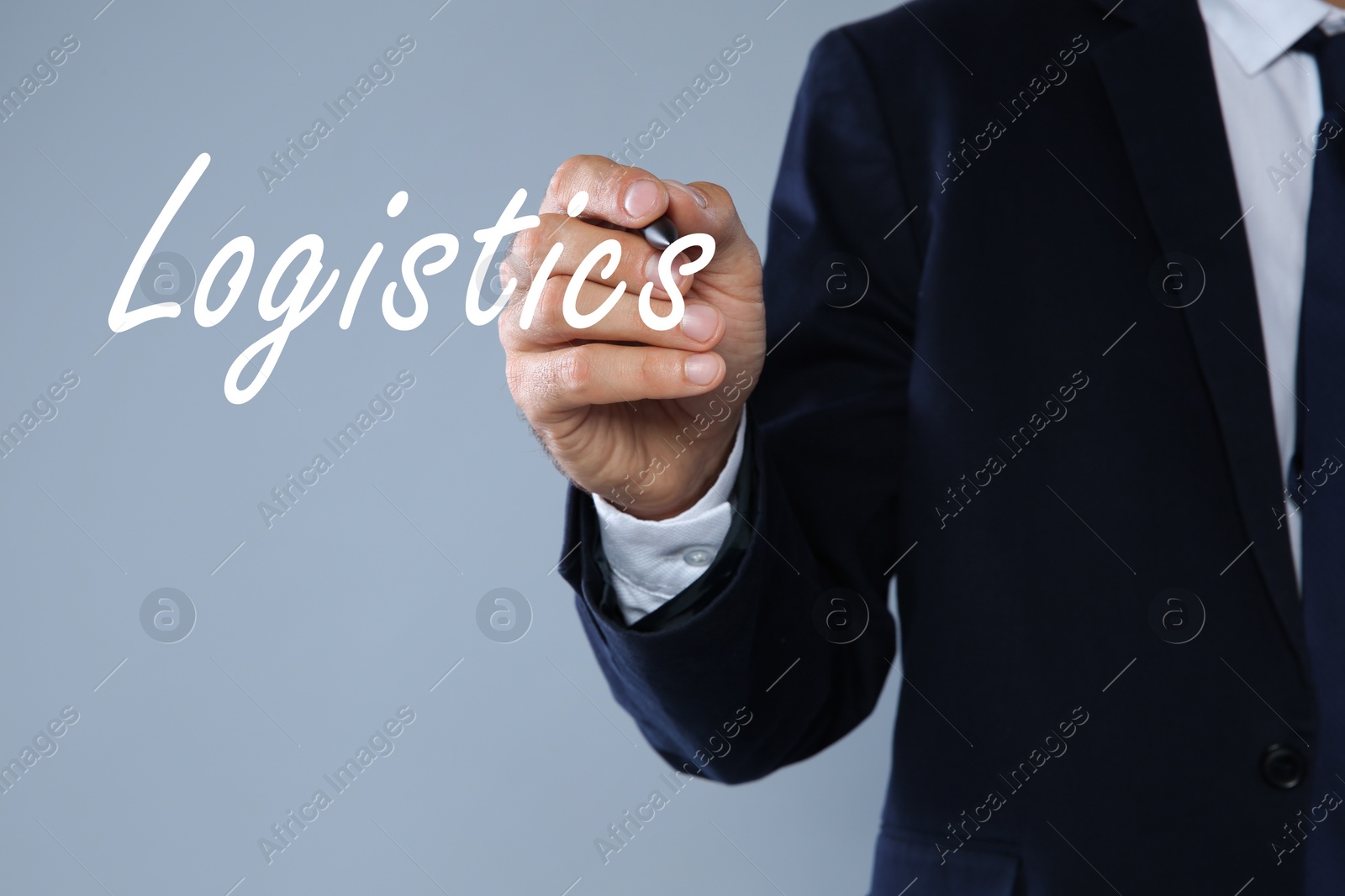 Image of Businessman pointing at word LOGISTICS on virtual screen against light background, closeup 