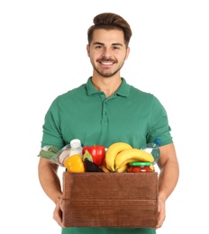 Photo of Young man holding wooden crate with products on white background. Food delivery service