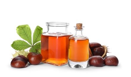 Photo of Horse chestnuts, bottles of tincture and green leaf on white background