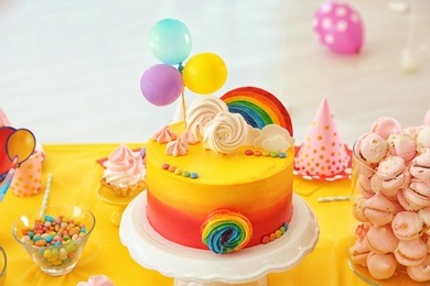 Photo of Table with birthday cake and delicious treats indoors