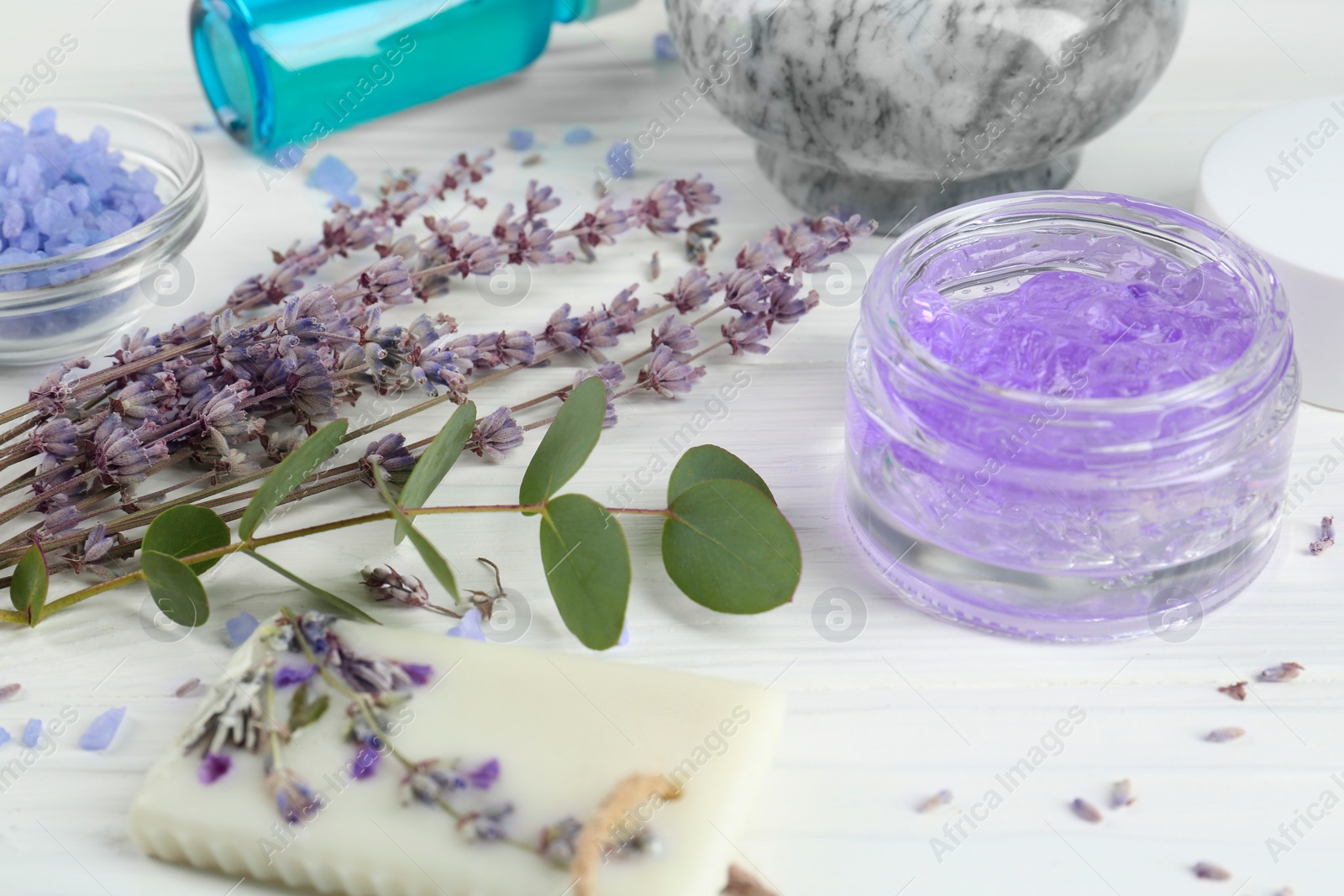 Photo of Homemade cosmetic products and fresh ingredients on white wooden table, closeup