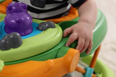 Photo of Little baby playing with toy walker, closeup