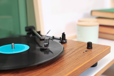 Photo of Stylish turntable with vinyl record indoors, closeup. Space for text