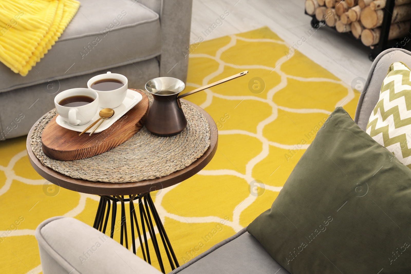 Photo of Cups of coffee and cezve on table in living room