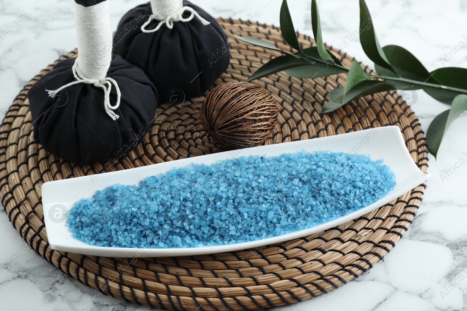 Photo of Composition with blue sea salt and herbal bags on white marble table