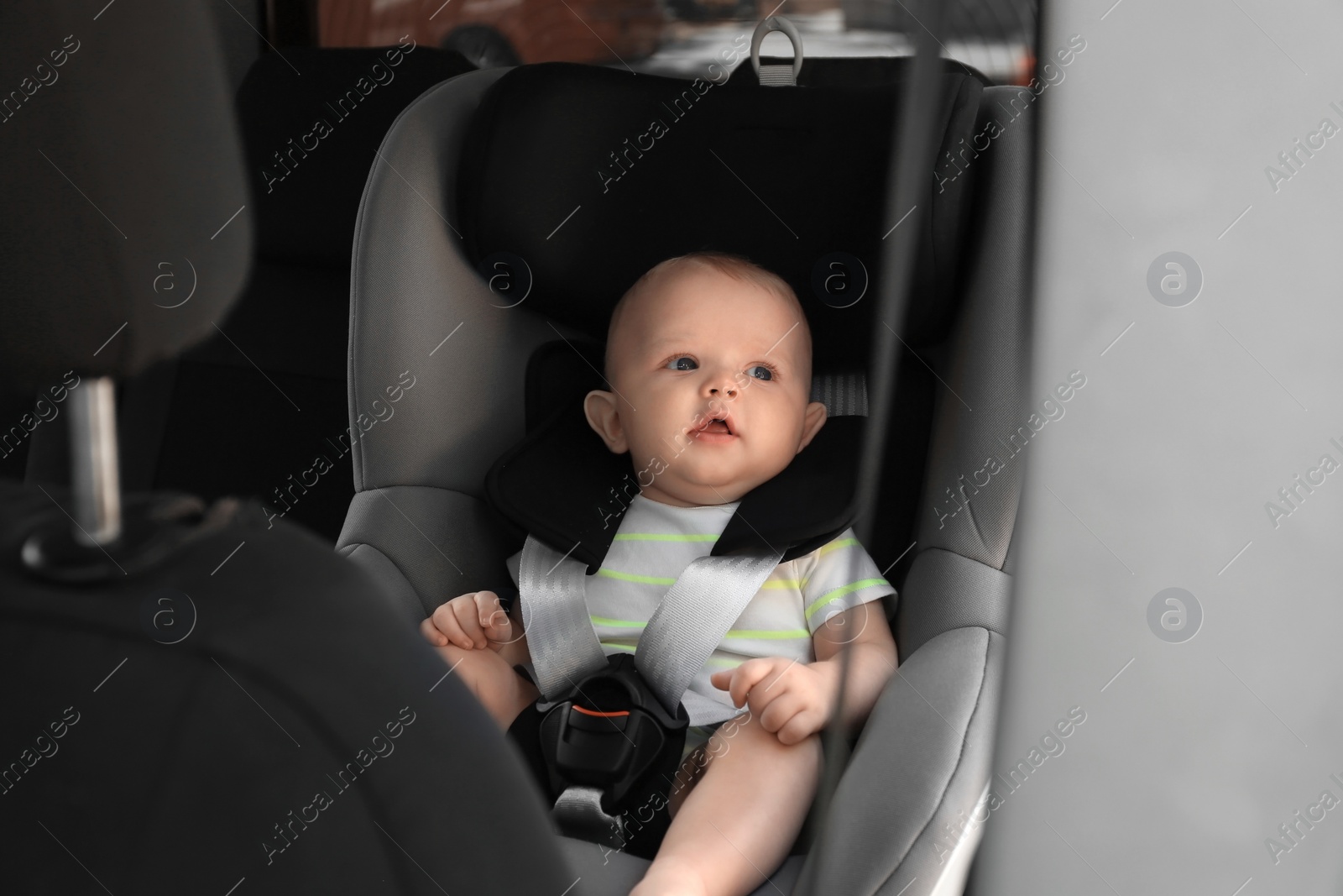 Photo of Little baby in child safety seat inside of car