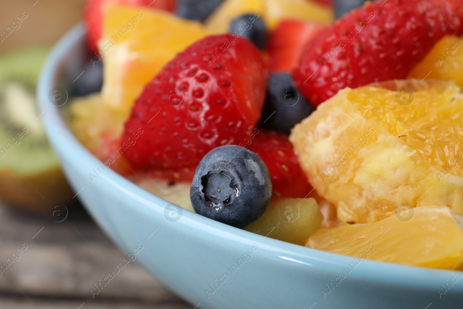 Photo of Delicious fresh fruit salad in bowl on table, closeup