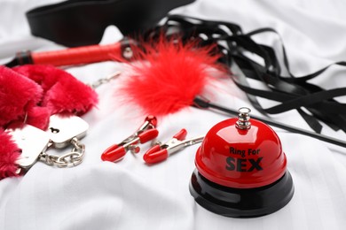 Photo of Sex toys and accessories on white fabric