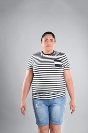 Photo of Fat woman on grey background. Weight loss