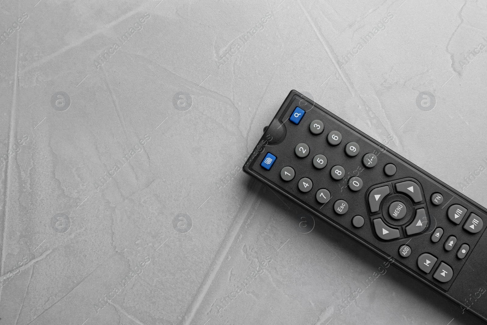 Photo of Modern tv remote control on grey table, top view. Space for text
