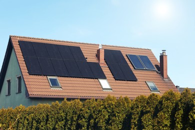 Photo of House with installed solar panels on roof. Alternative energy