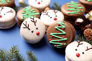 Beautifully decorated Christmas macarons on blue background, closeup