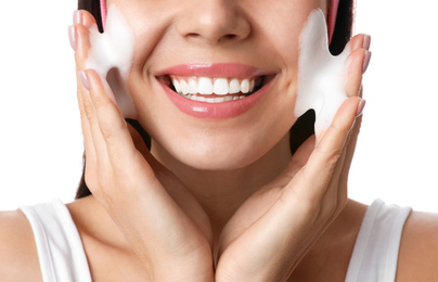 Photo of Young woman applying cosmetic product on white background, closeup. Washing routine