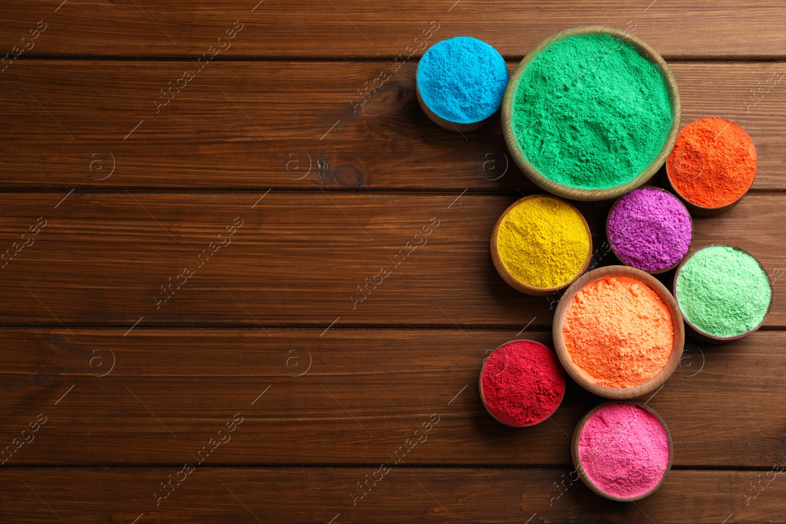 Photo of Colorful powder dyes on wooden background, flat lay with space for text. Holi festival