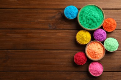Photo of Colorful powder dyes on wooden background, flat lay with space for text. Holi festival