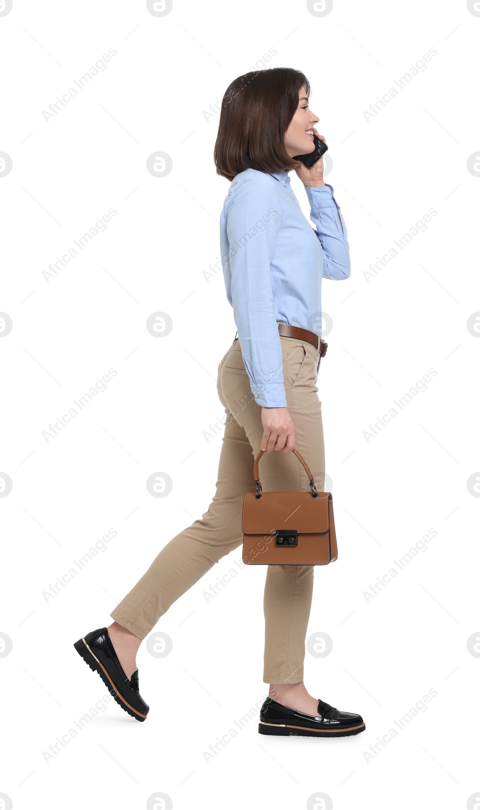 Photo of Happy woman with bag talking on smartphone against white background
