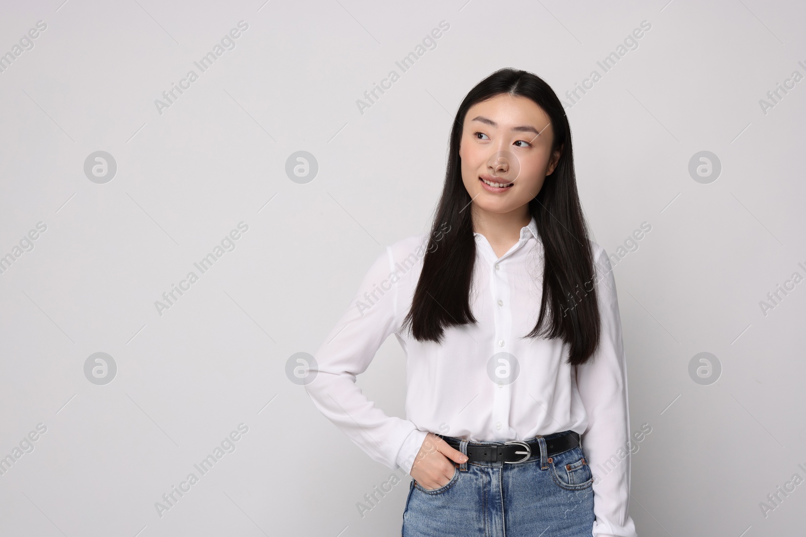 Photo of Portrait of smiling woman on light background. Space for text