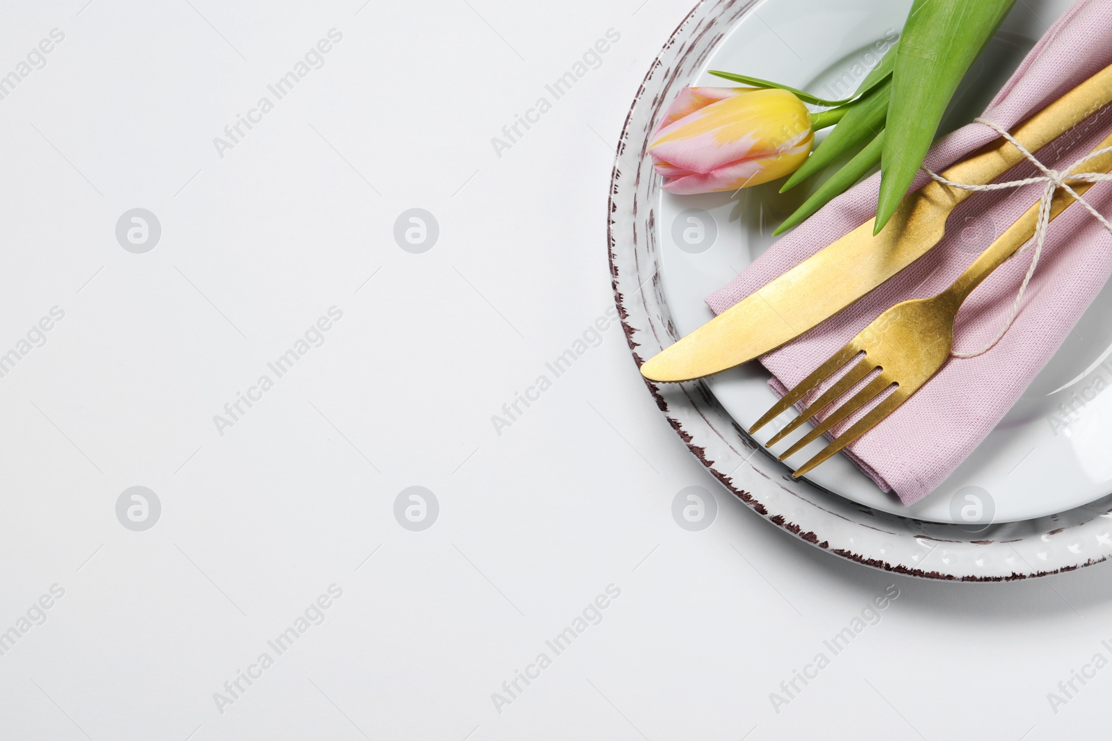 Photo of Stylish table setting with cutlery and tulip on white background, flat lay. Space for text